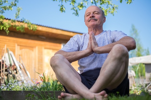 senior man meditating in the park